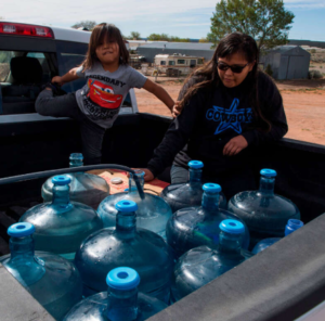 Members of the Larson family, who have no running water in their home, collect water from a distribution point in the Navajo Nation town of Thoreau in New Mexico on May 22, 2020.